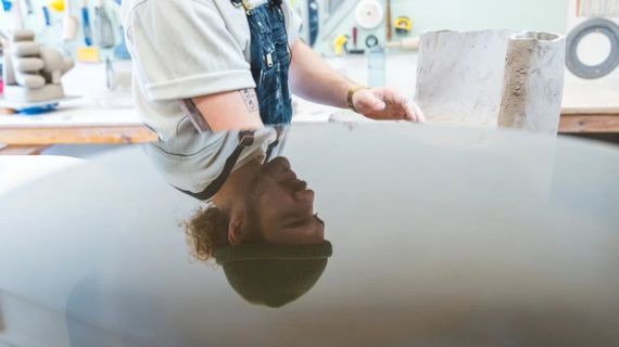 Photo of Austin Coudriet. His head and face are reflected on a wet surface.