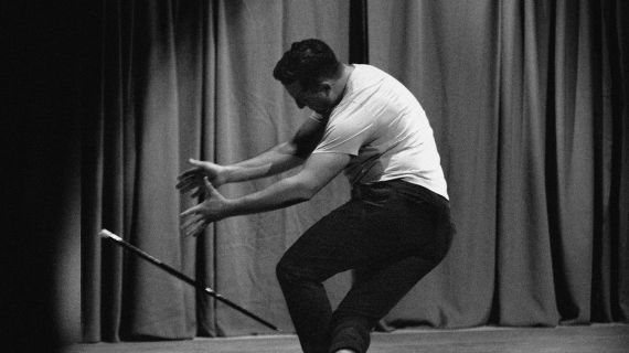 Photo of Rhett Guter dancing with a magic wand. Promotional image for "Cry Wolf: A Play With Magic."