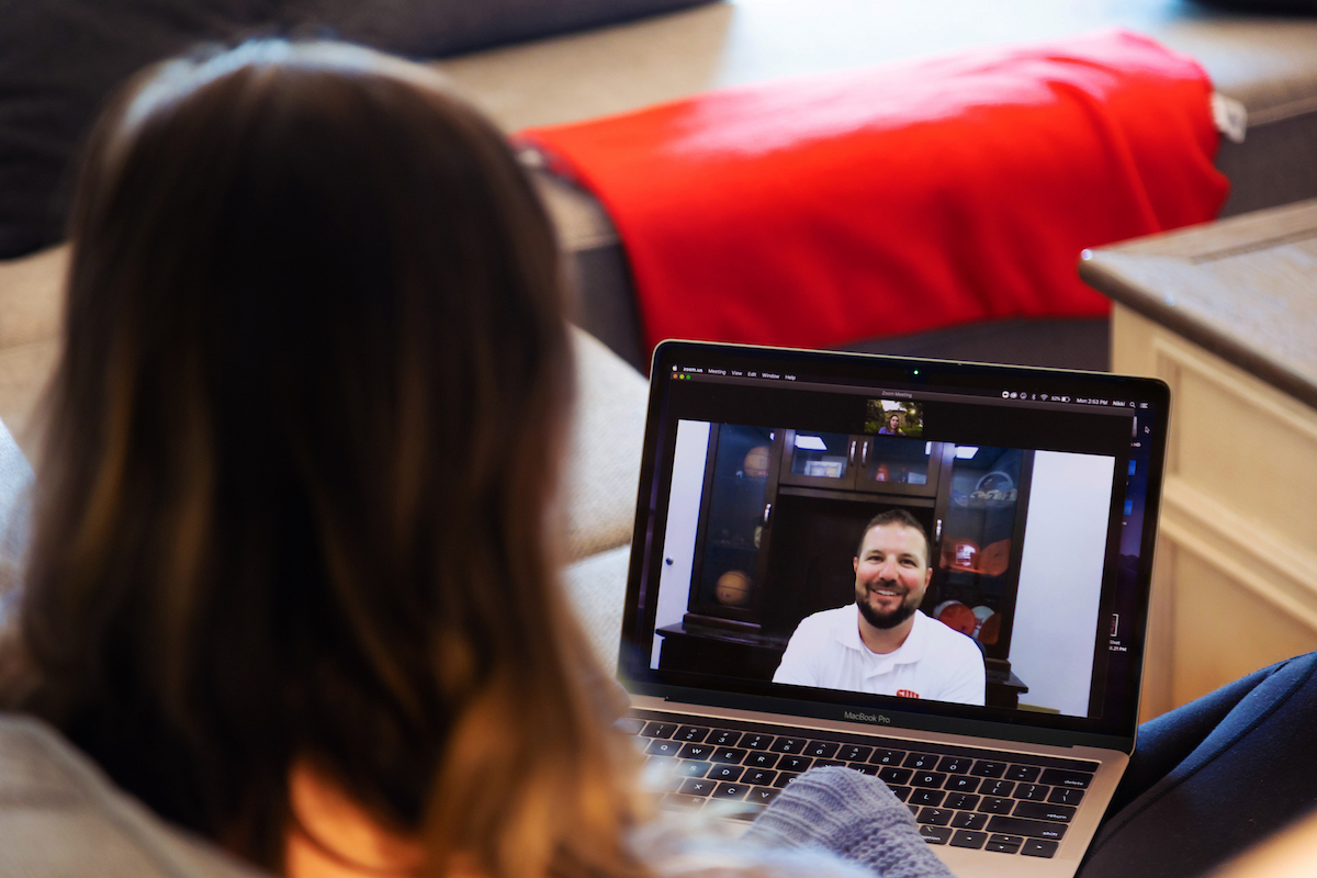 female student watching male speaker on laptop