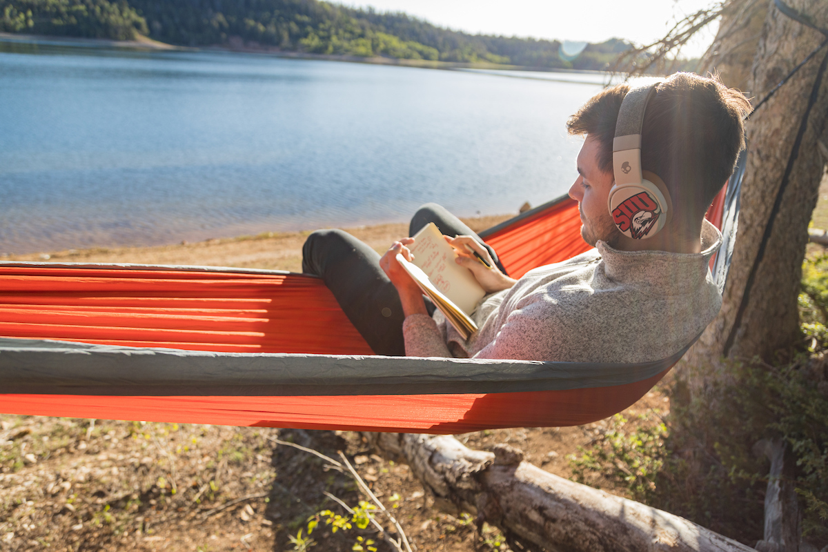male suu student in hammock reading book