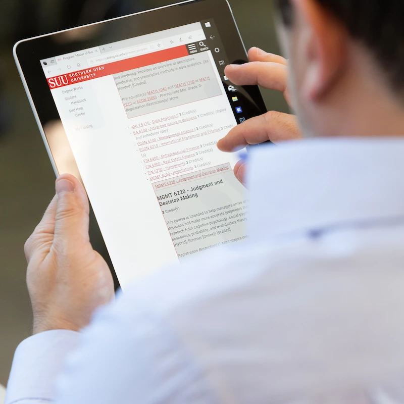 Man looking at SUU online courses on an ipad