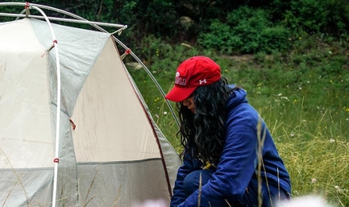 Student setting up white and grey tent 
