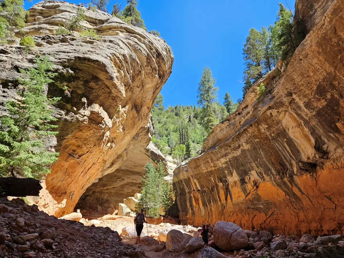 A hiker standing between two cliff walls that tower on either side 4
