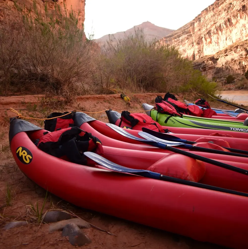 Inflatable Kayaks lined up on a riverbank