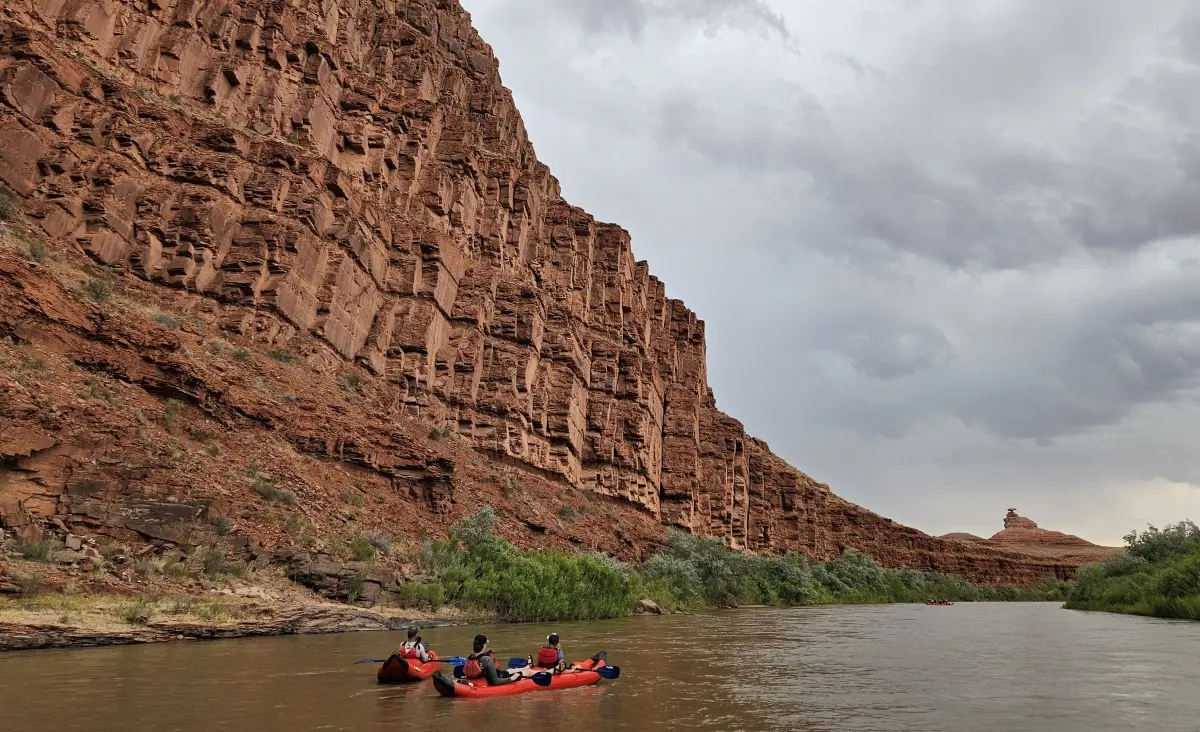 A group of people in kayaks floating down a river