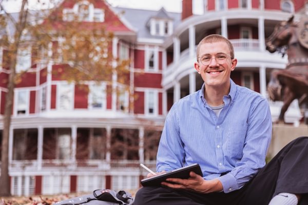 Student celebrating graduation in cap and gown for the Southern Virginia University partner graduate program with Southern Utah University