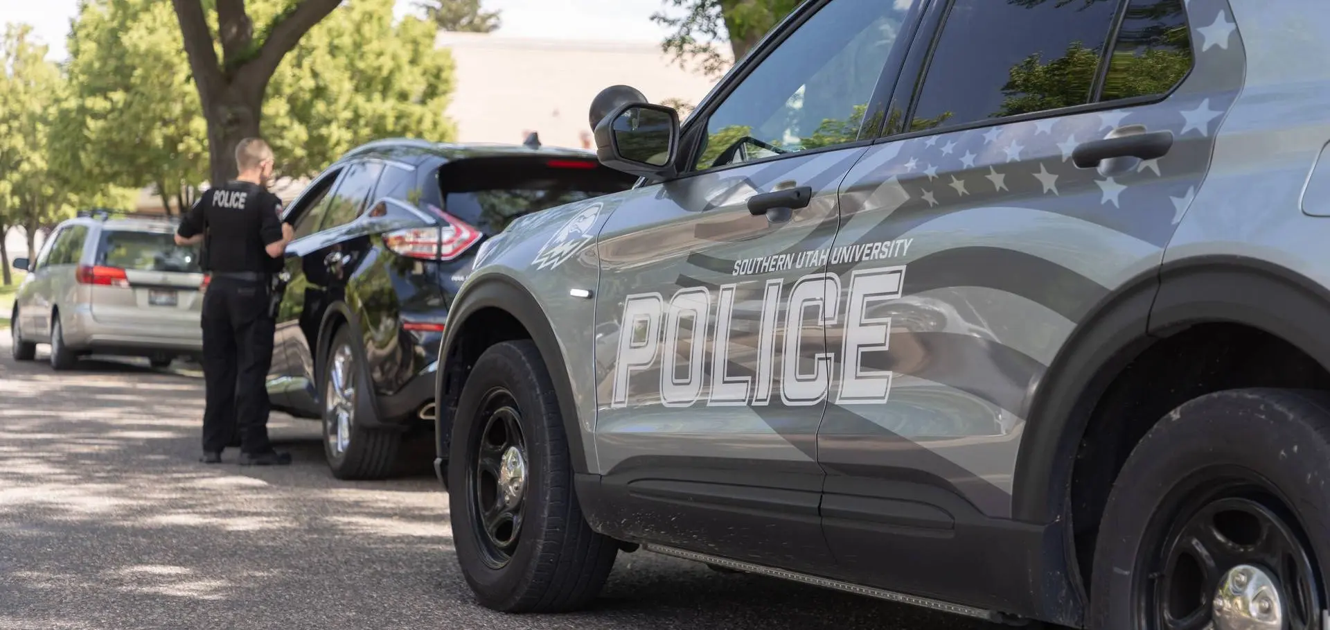 An SUU Police officer talking to a person driving a motorized couch.