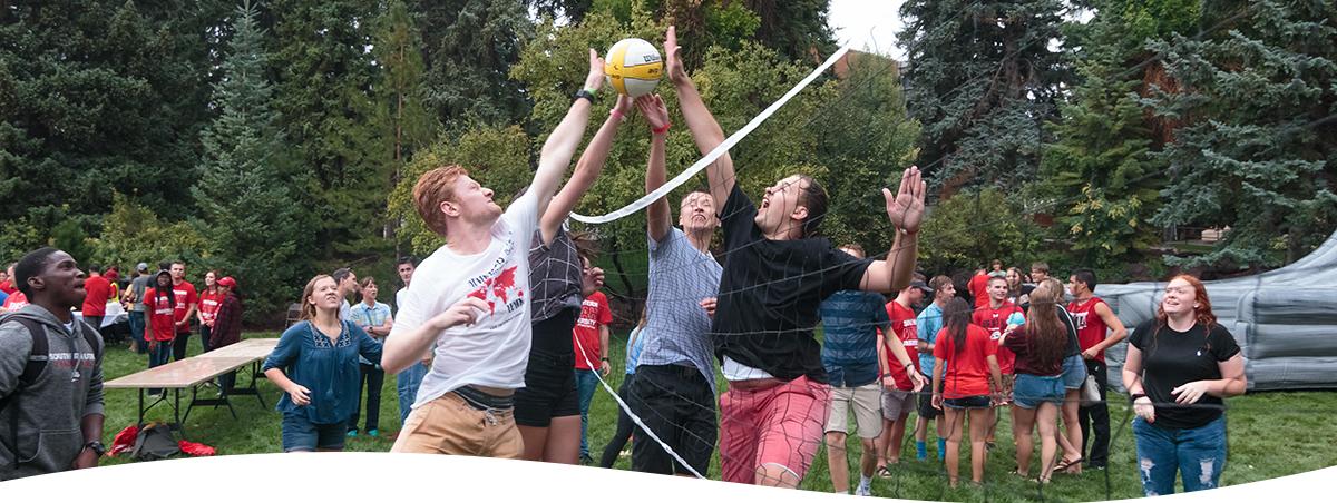 Group of SUU students playing volleyball outside