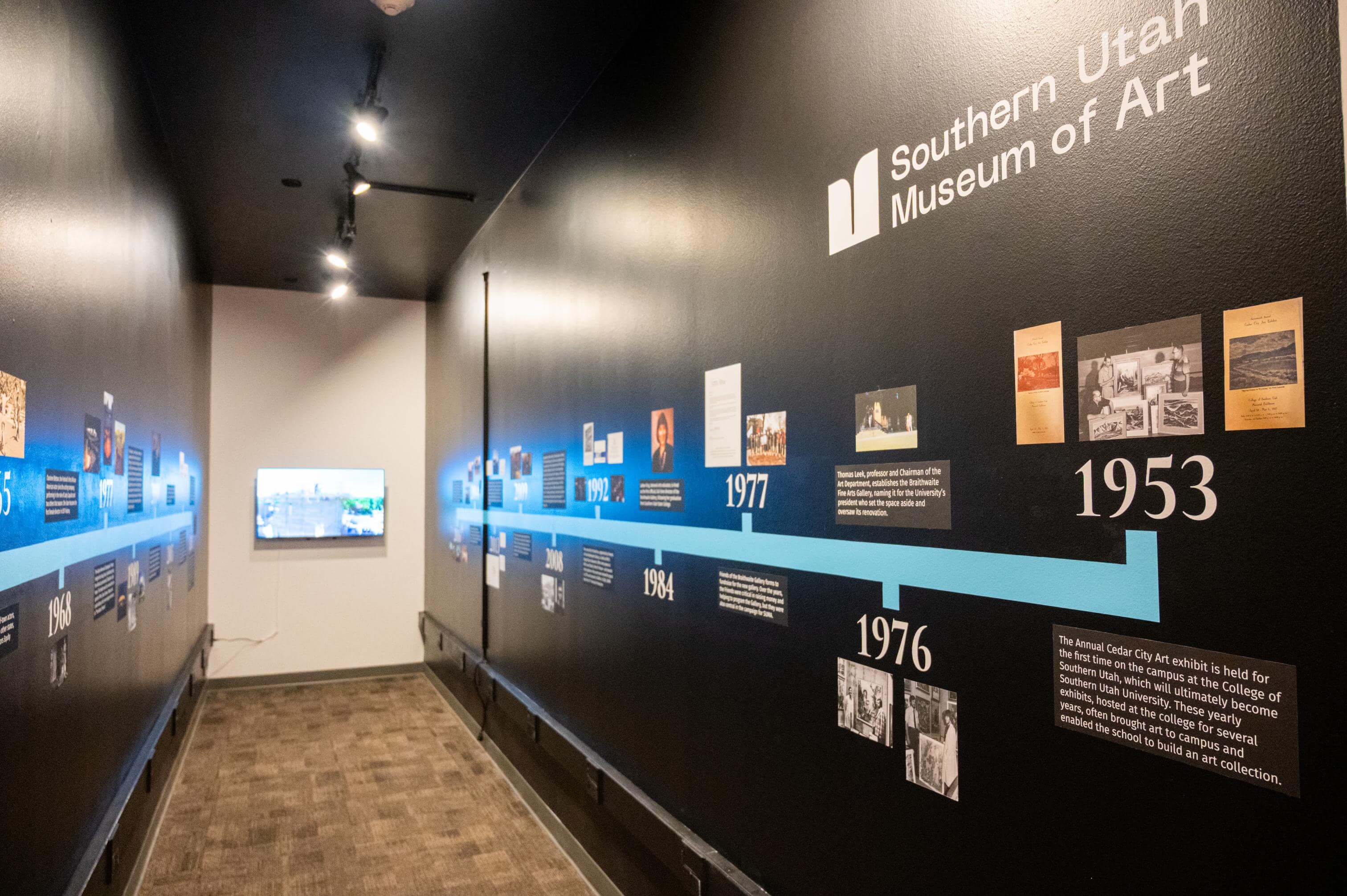 A look into the exhibition hallway featuring a timeline of dates, text and photos