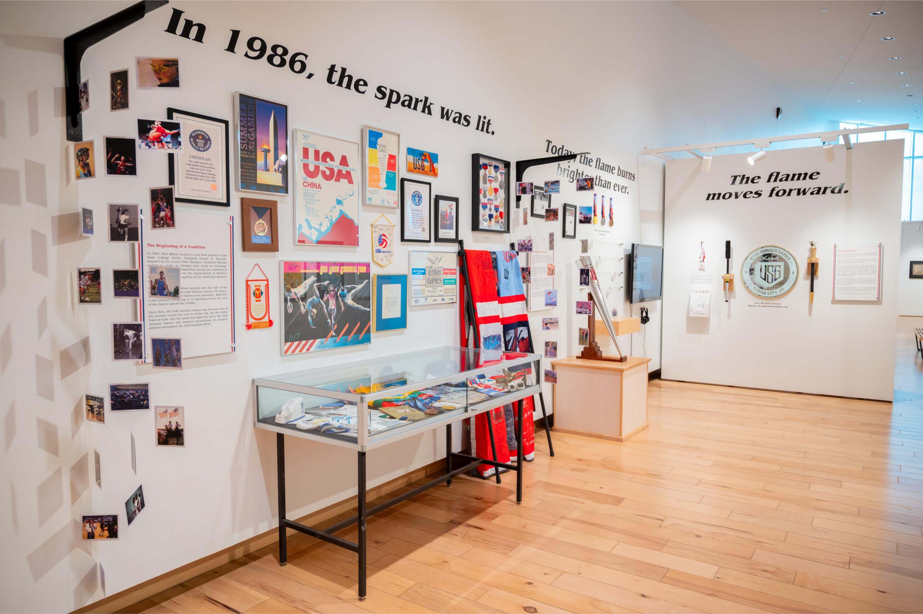 A display of memorabilia including medals, photos, t-shirts, and posters celebrating 40 years of the Larry H. Miller Utah Summer Games