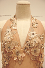 A peach-colored Casadei dress adorned with fabric flowers