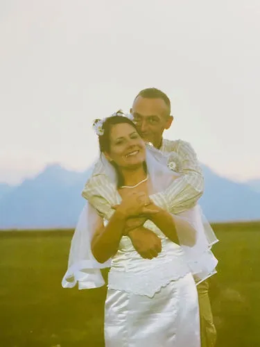 A vintage style photo of a bride and groom smiling outdoors