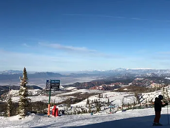 A wide view of a ski resort filled with snowy mountains and slopes.