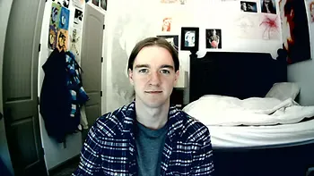 A wide angle view of a person sitting in a bedroom