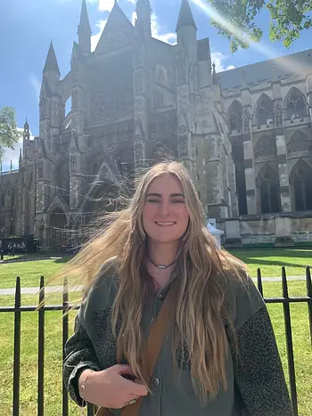 A photograph of a woman smiling in the bright sun