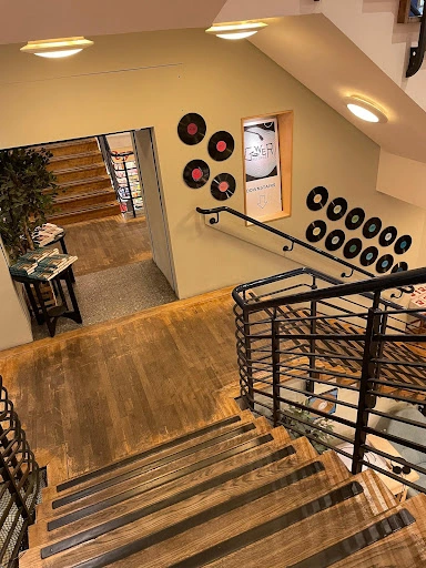 A wooden staircase with vinyl records mounted on the walls.