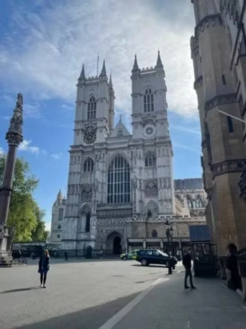A tall gothic cathedral with two towers, viewed from an open plaza.